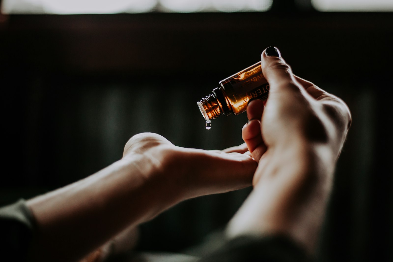 Massage oil being poured into a therapist's hand
